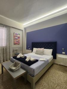 a bedroom with a large bed with a blue wall at 5 cupole in Palermo