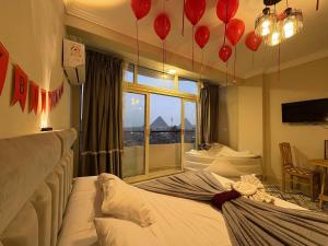 a room with a bed with a window and red balloons at Farida Pyramids inn& Jacuzzi in Cairo +115 photos