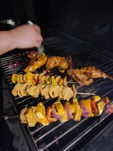 a person is cooking food on a grill at Vidman Homey Huts in Tindummal
