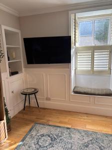 a living room with a flat screen tv and a window at The townhouse in Stornoway