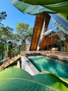 a house with a swimming pool next to a building at Ceylon Canopy in Hiriketiya