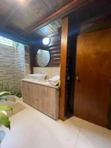 a bathroom with a sink and a wooden door at Chalet Palo DAgua in Turbaco +52 photos