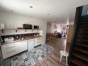 a kitchen with white cabinets and a black and white rug at Sylina Spa avec Jacuzzi Privé in Villeblevin