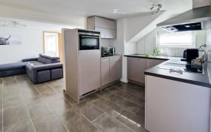 a kitchen with a refrigerator and a couch in a room at Chalet Bellevue Beautiful Waterfall view private Garden & free parking in Lauterbrunnen +11 photos