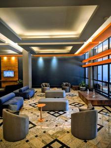 a lobby with couches and tables in a building at Minas Garden Hotel in Poços de Caldas