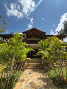a house with palm trees in front of it at Cabaña Barichara in Barichara