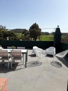 a patio with white chairs and tables and chairs at La Macadamia in Las Lagunas