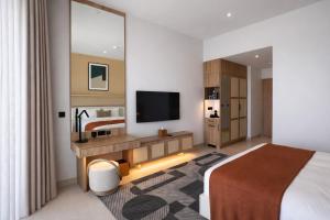 a hotel room with a bed and a flat screen tv at Daraah Resort - AMAALA in Ţaraf Shaqq al ‘Abd +9 photos