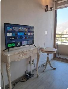 a living room with a table with a television on it at Plaza ñuñoa in Santiago