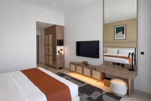 a bedroom with a large bed and a television at Daraah Resort - AMAALA in Ţaraf Shaqq al ‘Abd