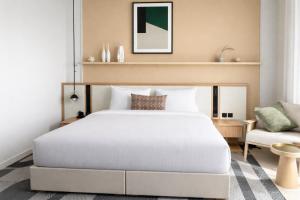 a bedroom with a white bed and a couch at Daraah Resort - AMAALA in Ţaraf Shaqq al ‘Abd