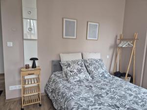 a bedroom with a bed and a wooden night stand at St FURSY 2 in Péronne
