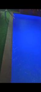 ein blauer Swimmingpool mit einer Bank daneben in der Unterkunft Plot1 Suits in Ibadan