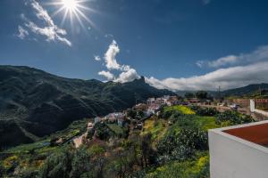 a village on a hill with the sun in the sky at Nature in Tejeda in Tejeda
