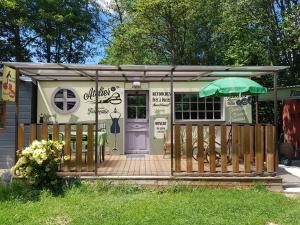 a small building with a porch and an umbrella at Le Riolet in Marsac-en-Livradois