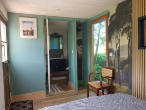 a bedroom with a blue wall with a mirror at Le Riolet in Marsac-en-Livradois