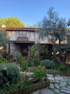 a stone house with a garden in front of it at Pavelin yeri in Altınoluk