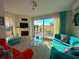 a living room with a blue couch and a large window at Evalacati - Villa Harnup- Detached house with private pool and garden in Alaçatı