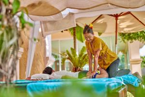 a woman is playing with a person on a bed at Avalon Beach Resort Pattaya in Pattaya South