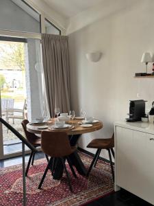 a dining room with a table with wine glasses on it at BelleVie Apartment, Eijsden-Maastricht in Eijsden