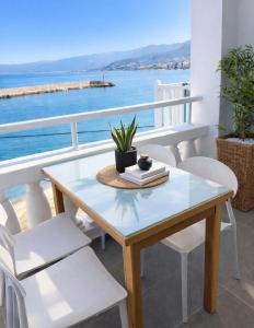 a table and chairs on a balcony with the ocean at Opal Apartments Luxury by the Sea in Hersonissos