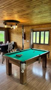a room with a pool table in a house at Chalé do Lago - Refúgio Arara Azul in Urubici