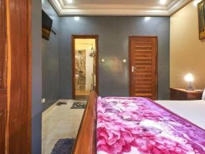a bedroom with a bed with a pink blanket at Tekrour- la case des hôtes- Suite privée-chambre, salon et cuisine complete in Mbour +36 photos