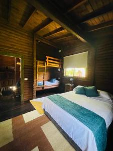 a bedroom with a large bed and bunk beds at Chalet Palo DAgua in Turbaco