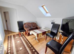 a living room with a leather couch and two chairs at Agrokrysia in Krosʼtsenko