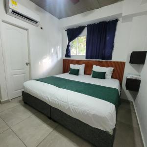 a bedroom with a large bed with a window at Hostal Casa Marle in Puerto Colombia