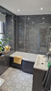 a bathroom with a bath tub and a sink at The Geo Apartment in Montrose