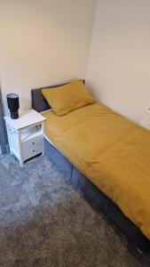a bed in a room with a night stand next to it at The Geo Apartment in Montrose