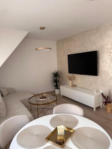 a living room with a couch and a tv on a wall at Apartment Kala in Varaždin