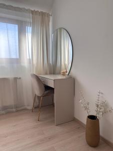 a dressing table with a mirror and a chair in a room at Apartment Kala in Varaždin