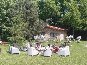a group of people sitting around a table in the grass at Hosteria na Mazurach in Dąbrówno