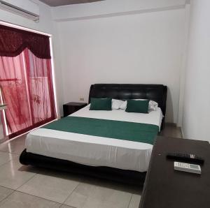 a bedroom with a large bed and a desk at Hostal Casa Marle in Puerto Colombia