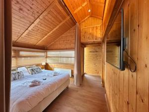 a bedroom with a large bed in a wooden house at Chalet Olive in Durbuy