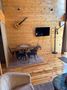 a room with a wooden wall with a table and a guitar at Driftwood Dreams in Cetinje +12 photos