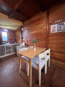 a wooden dining room with a wooden table and chairs at Cabin Hillside Dieng in Diyeng