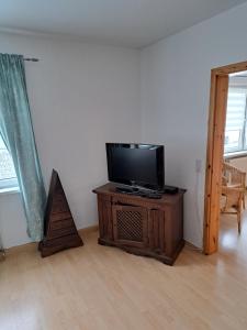a living room with a flat screen tv on a wooden cabinet at Ferienhaus Boddensicht in Breege