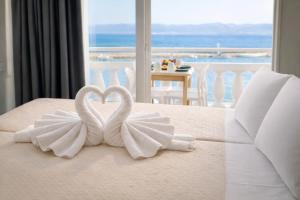 two white swans making a heart on a bed at Opal Apartments Luxury by the Sea in Hersonissos