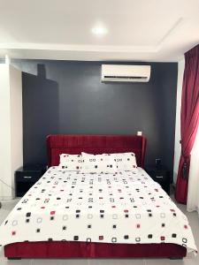 ein Schlafzimmer mit einem Bett mit rotem Kopfteil in der Unterkunft Rontop in Gwarinpa