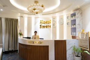 a man standing at a counter in a salon at Hotel Smart Durbar in Dharampur