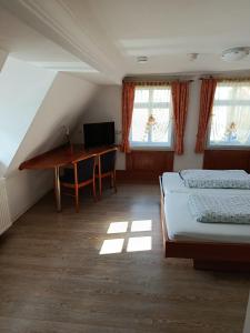 a bedroom with two beds and a desk in it at Pension Webstuhl in Deizisau