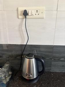 a tea kettle plugged into an electrical outlet at Rainbow721 in Pondicherry