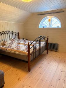 a bedroom with a bed in a room with a window at Kyrkåsen in Borgvik