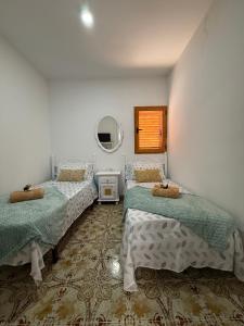 a bedroom with two beds and a mirror at Nature in Tejeda 2 in Tejeda