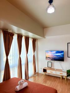 a bedroom with a bed and a large window at Abreeza place T-2 in Davao City
