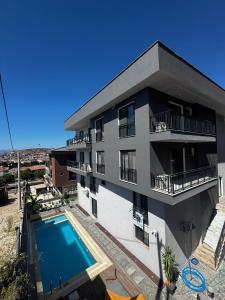 an apartment building with a swimming pool in front of it at Maia Suites in Çeşme