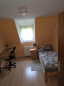 a bedroom with a bed and a desk and a window at Sebol in Immendingen